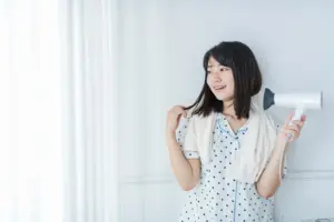 ドライヤーで髪を乾かす人