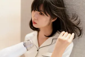 ドライヤーで髪を乾かす女性