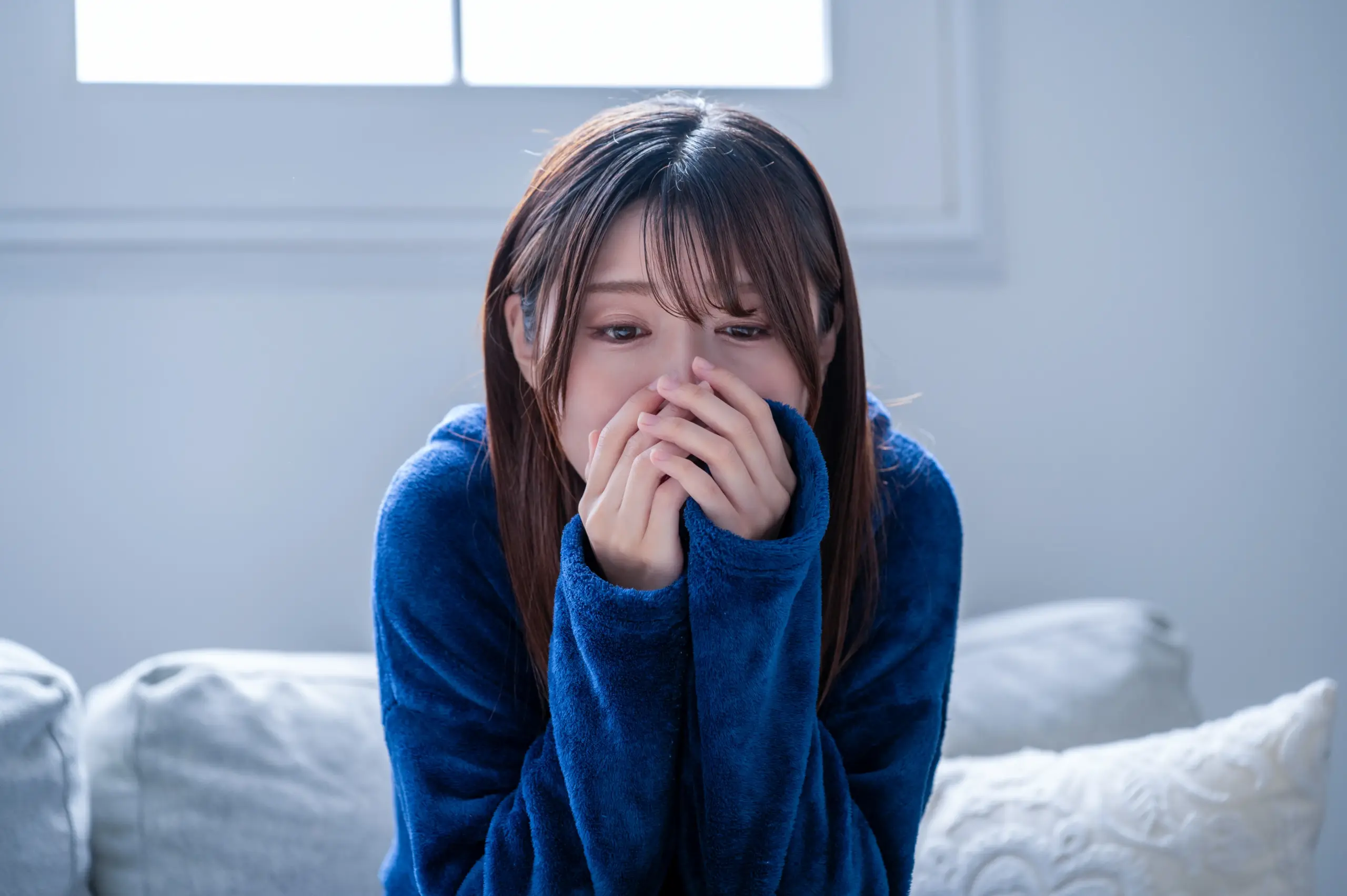 冬の朝の冷え込みで震える女性